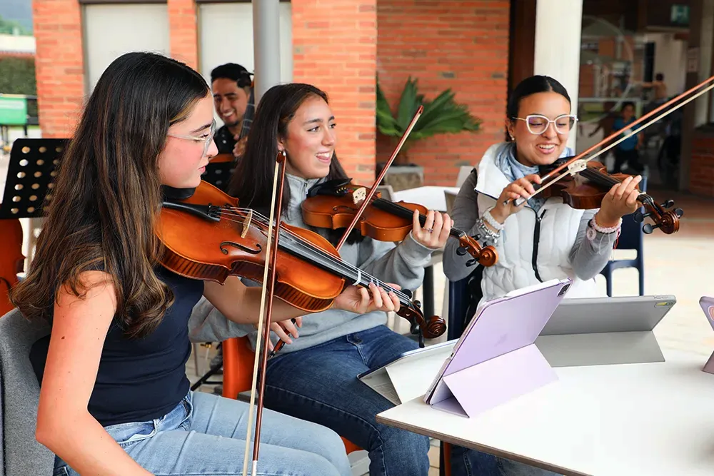 Estudiantes ensayan violín en un espacio de arte y música del Gimnasio La Montaña